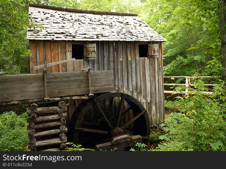 A weathered water whee and milll set in a heavily wooded area. A weathered water whee and milll set in a heavily wooded area.