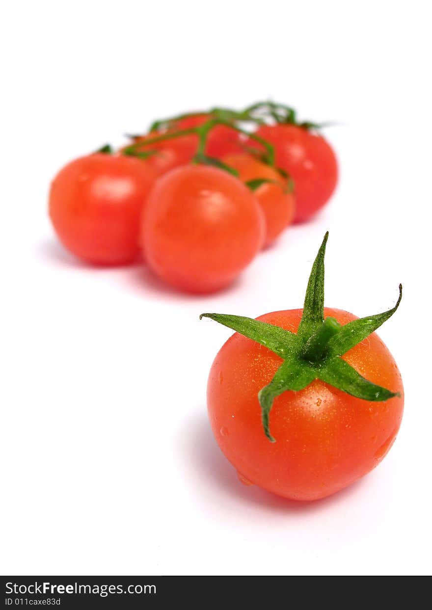 Cherry tomatoes together and one of that is alone, on a white background