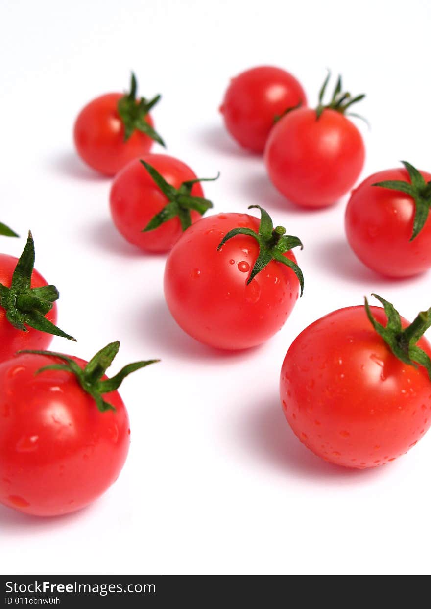 Cherry tomatoes together forming a line on a white background