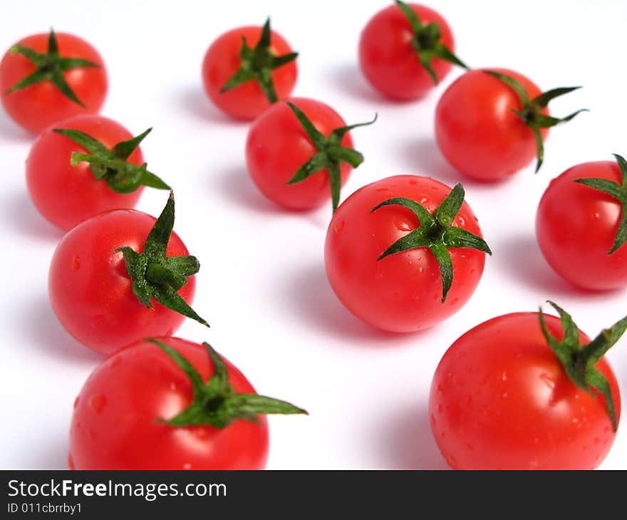 Cherry tomatoes together forming a line on a white background