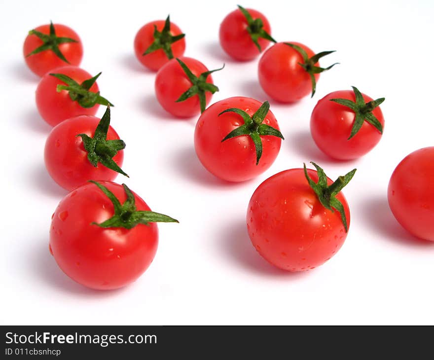 Cherry tomatoes together forming a line on a white background