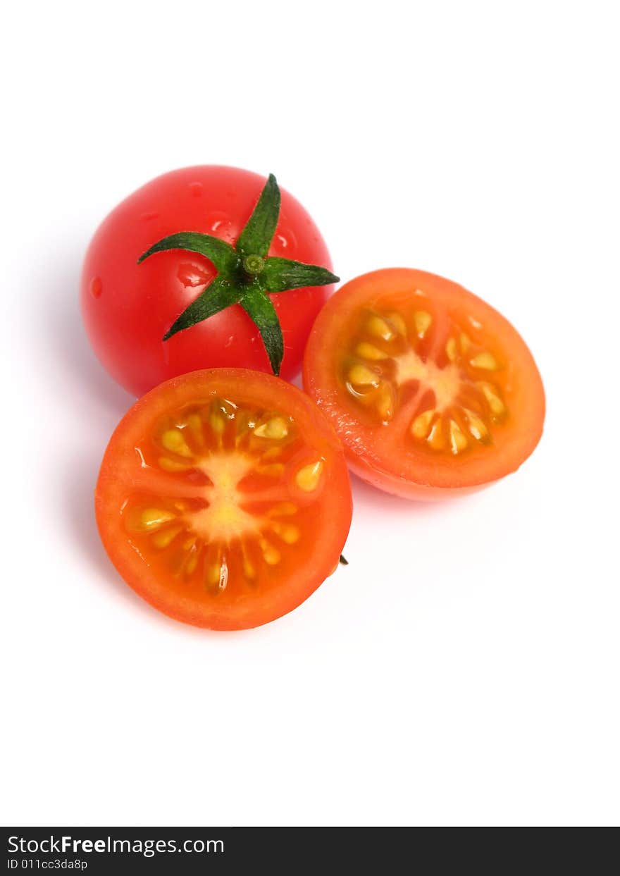 Two cherry tomatoes together and one is cut in the middle, on a white background