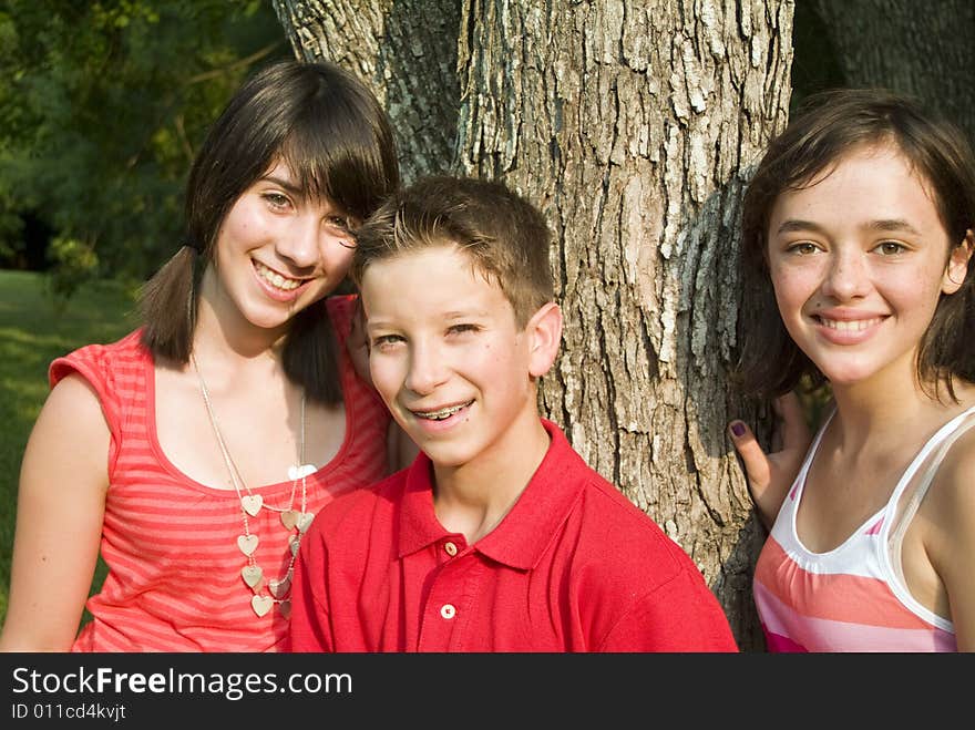 Three youngsters under some trees with pensive, faraway looks on their faces. Three youngsters under some trees with pensive, faraway looks on their faces.