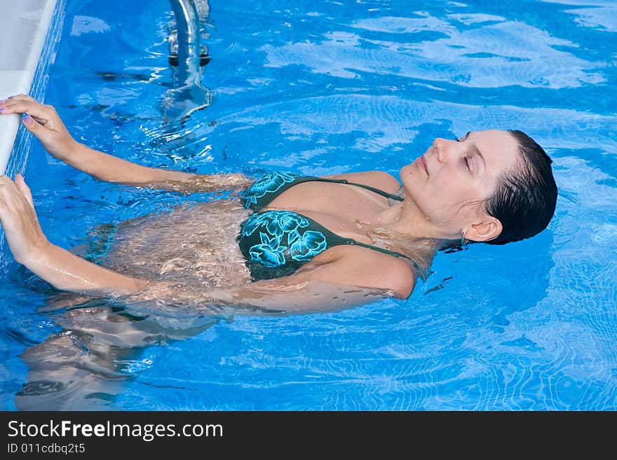 A beautiful woman relaxing in the pool