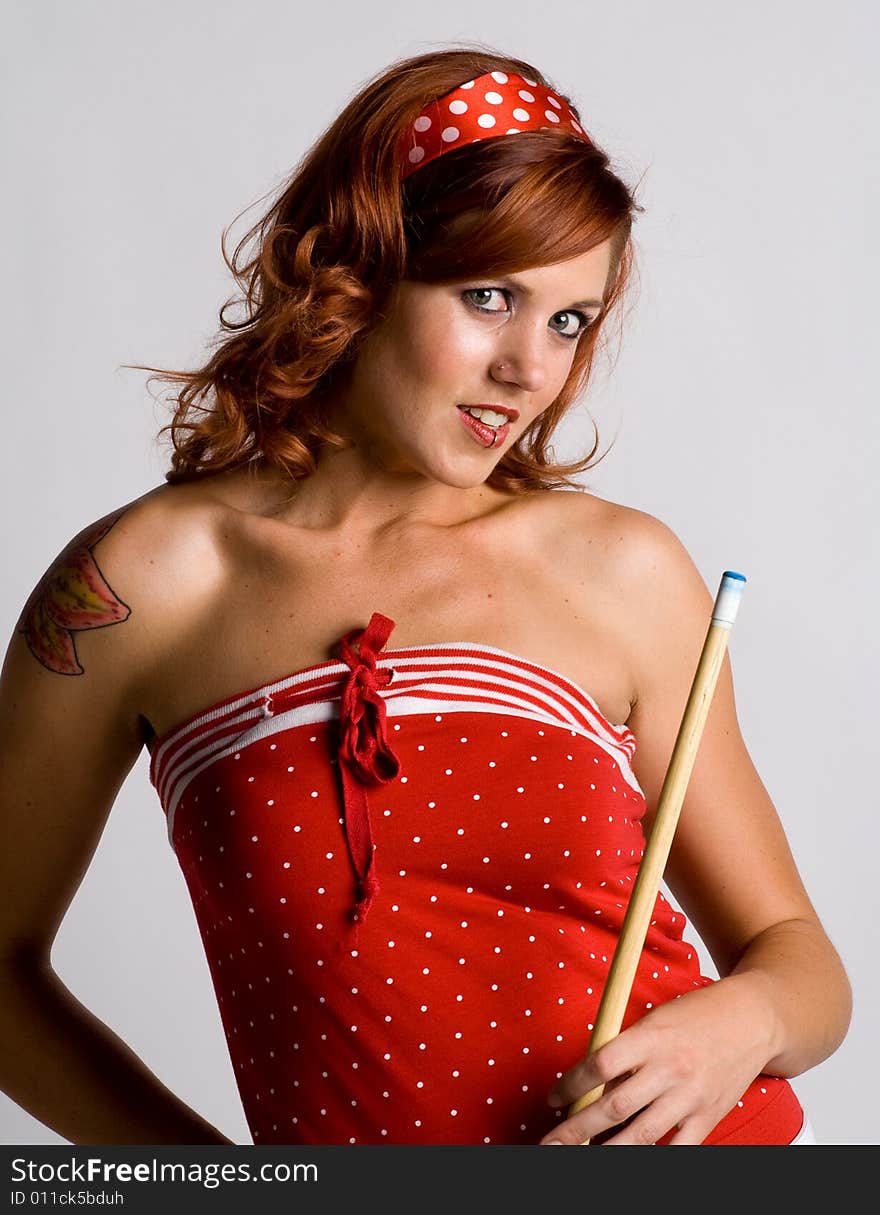 Redhead girl holding a pool cue