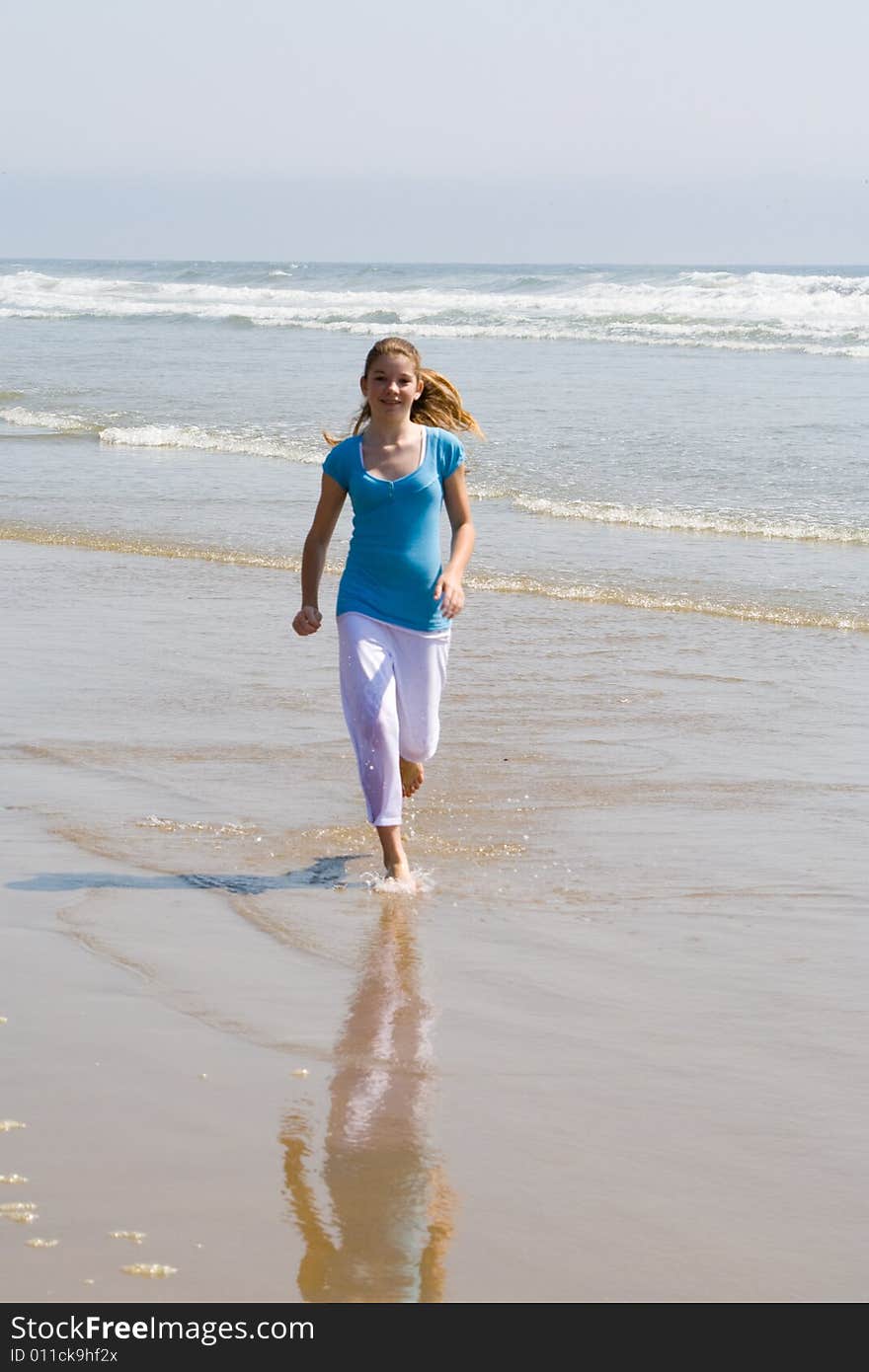 Young Teen Girl Running along the Ocean shore. Young Teen Girl Running along the Ocean shore