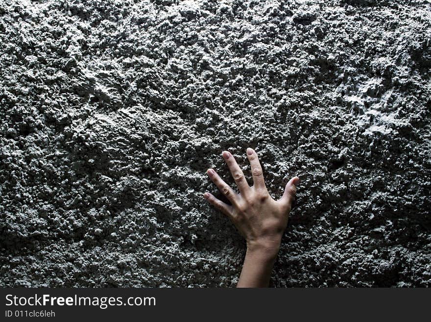 Female hand on stone wall