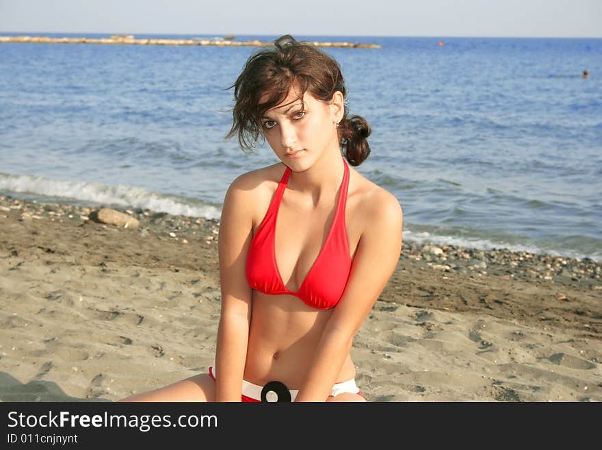 Pretty girl in red bikini on the sand.