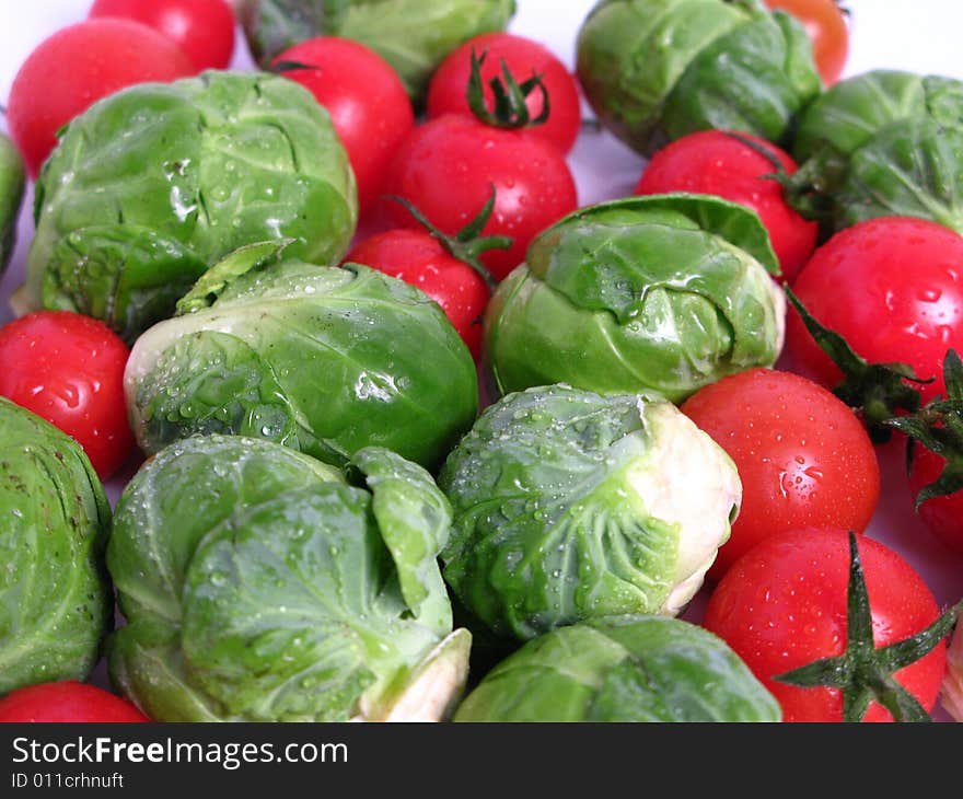 Fresh organic Brussels sprouts and cherry tomatoes, on white background. Fresh organic Brussels sprouts and cherry tomatoes, on white background