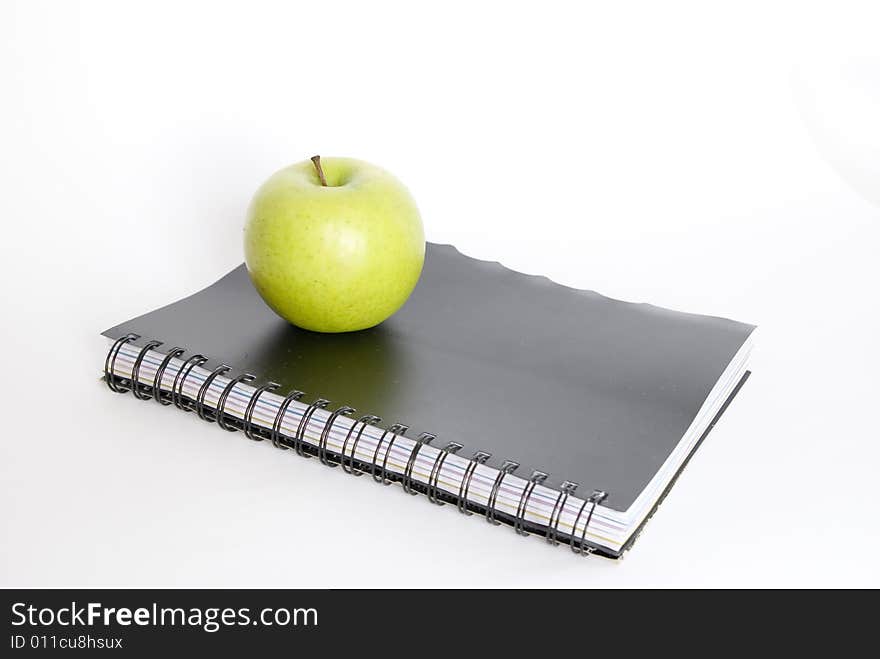 Green apple and book on white. Green apple and book on white