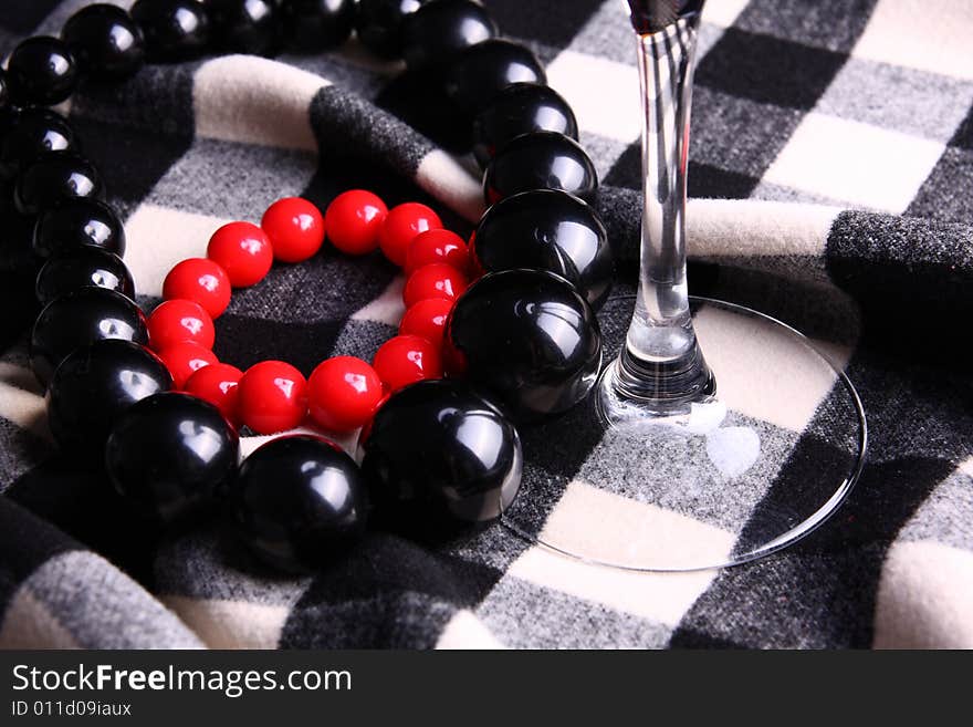 Beads necklaces and glass detail on checkerboard pattern. Beads necklaces and glass detail on checkerboard pattern