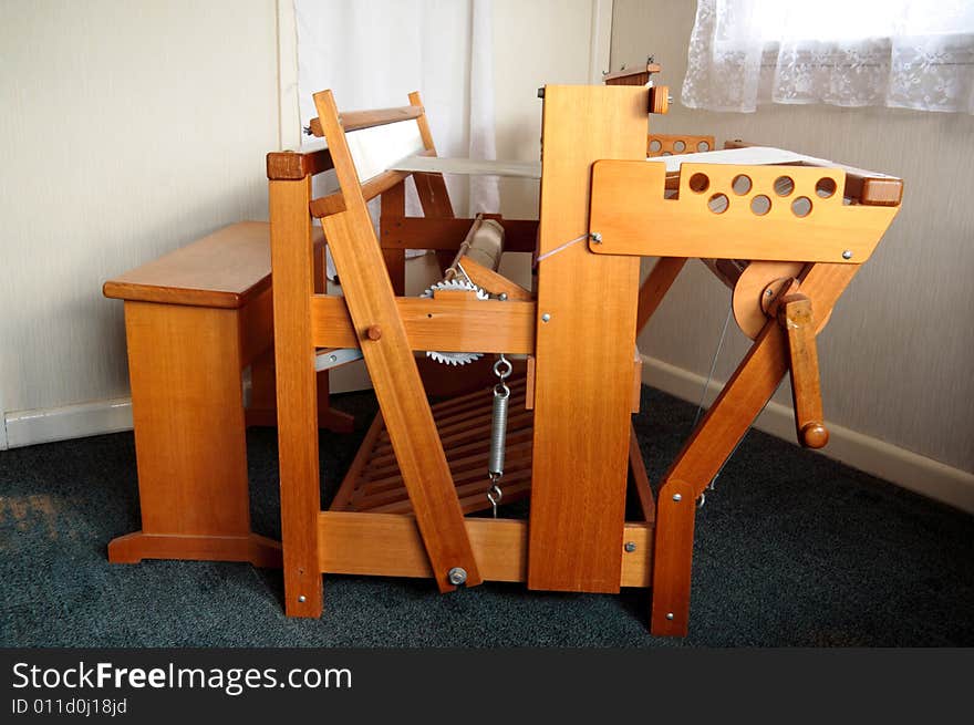 An old weaving loom viewed side on. An old weaving loom viewed side on