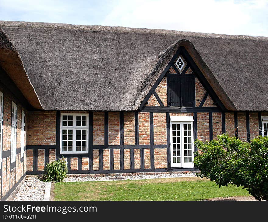 Traditional country farmhouse with old style thatched straw roof in Denmark. Traditional country farmhouse with old style thatched straw roof in Denmark