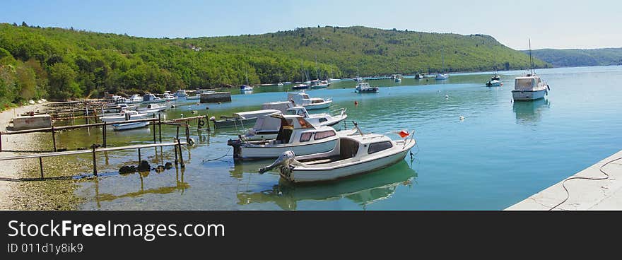 Bay panorama with fishing boats in the harbour, beautiful landscape Trget in Rasa Bay (Istria - Croatia) - suitable as card,postcard,tourism-related poster *panorama stitched with 2 horizontal images