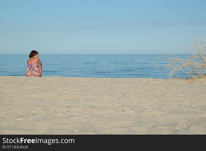 Young woman is sitting on the beach (2)