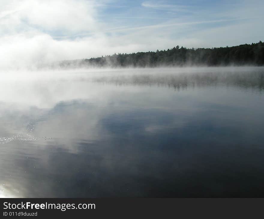 Mist rising from lake in Adirondacks as the sun rises.