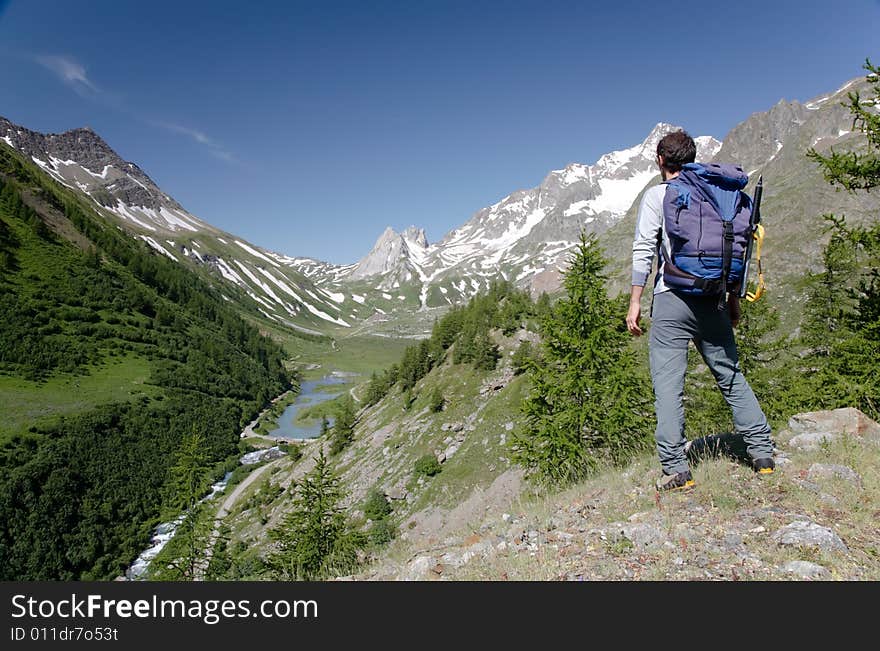 Male hiker enjoying the view over the beautiful landscape of Mige Lake, Mont Blanc, Courmayeur, Italy. Male hiker enjoying the view over the beautiful landscape of Mige Lake, Mont Blanc, Courmayeur, Italy