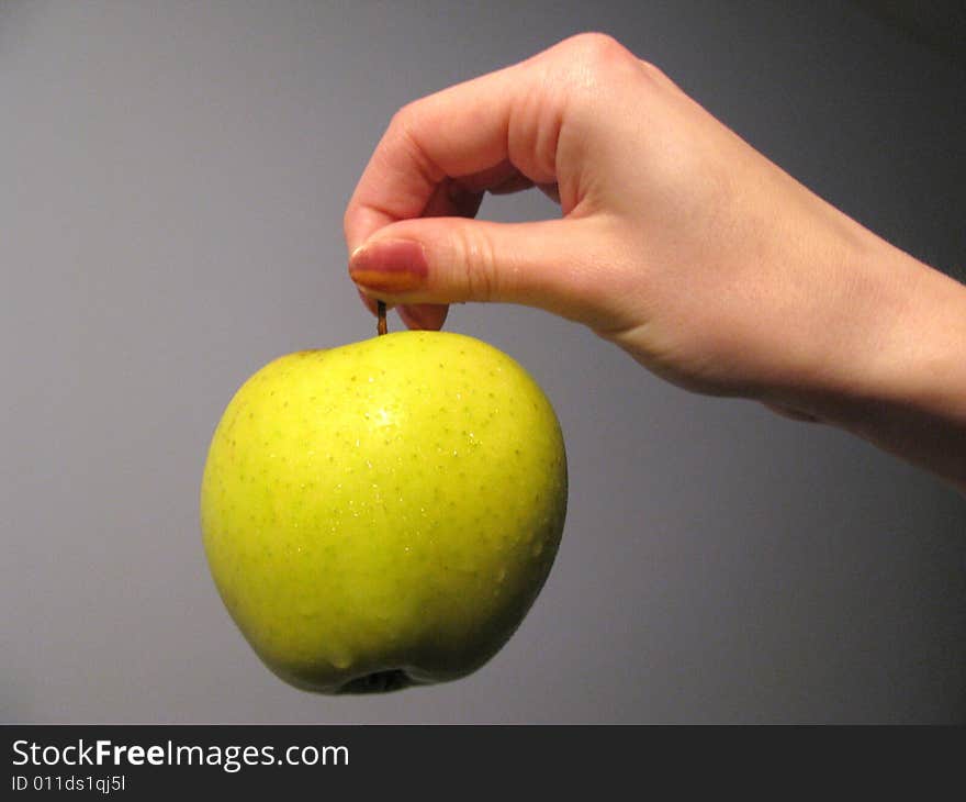 The hand with juicy green apple