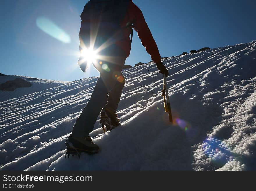 Lone male mountain climber climbing a snowy ridge; Mont Blanc, Europe.