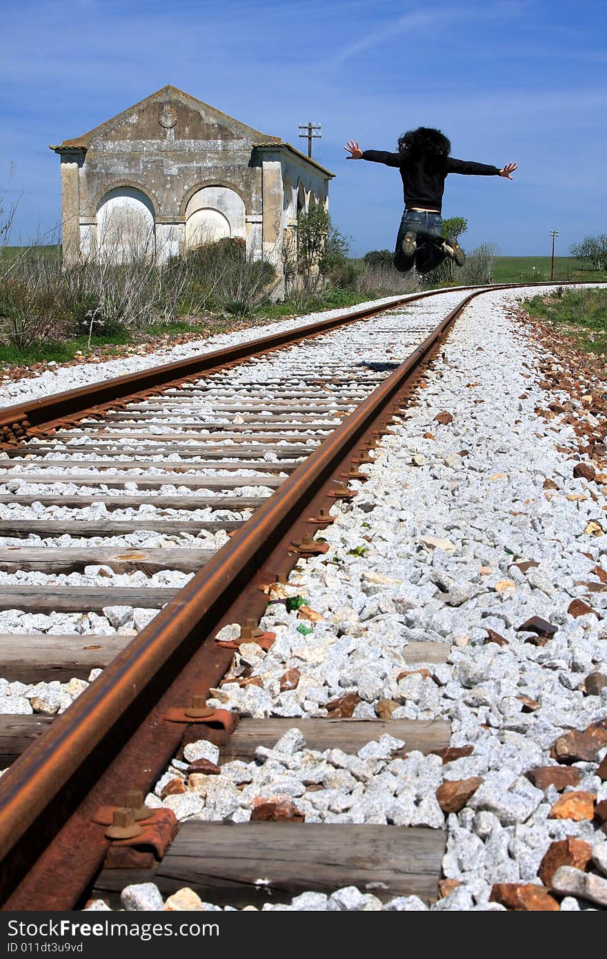 Young woman jumping on the railway of an abandoned train station. Young woman jumping on the railway of an abandoned train station.