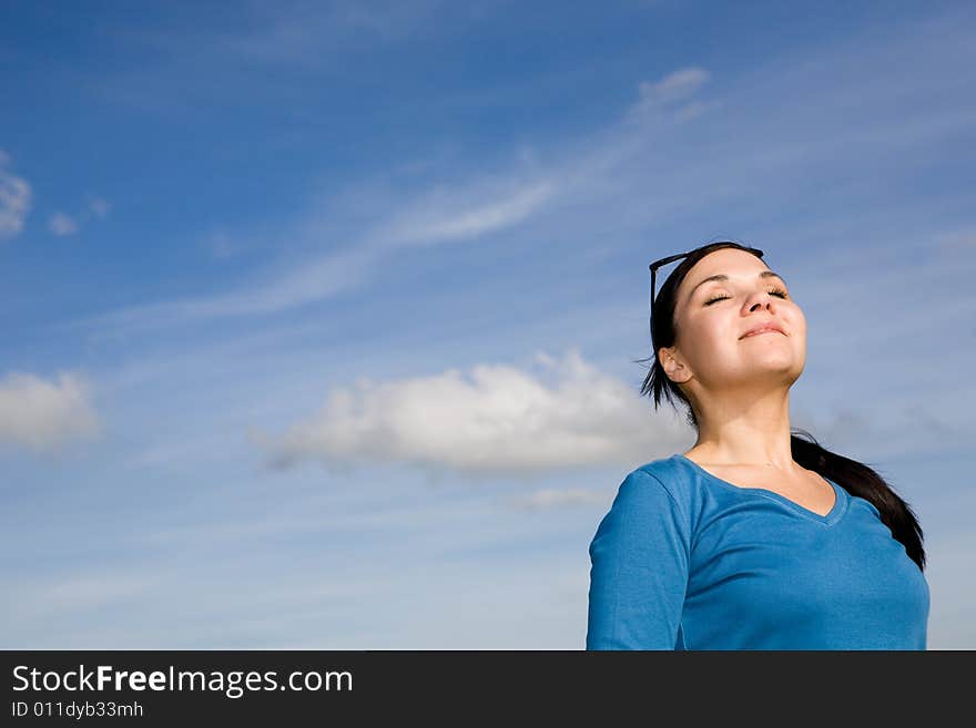 Attractive brunette woman relaxing on sky background. Attractive brunette woman relaxing on sky background