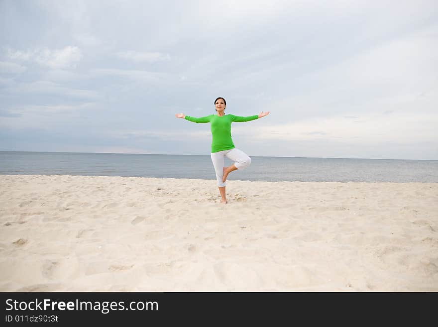 Attractive woman doing exercise on the beach