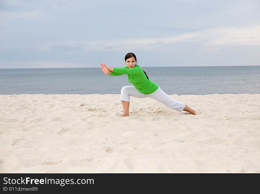 Attractive woman doing exercise on the beach