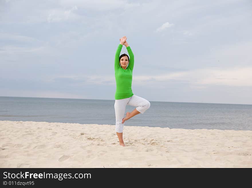 Attractive woman doing exercise on the beach