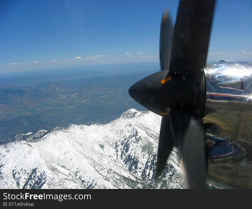 Looking past an airplane propeller to snow covered mountains. Looking past an airplane propeller to snow covered mountains.