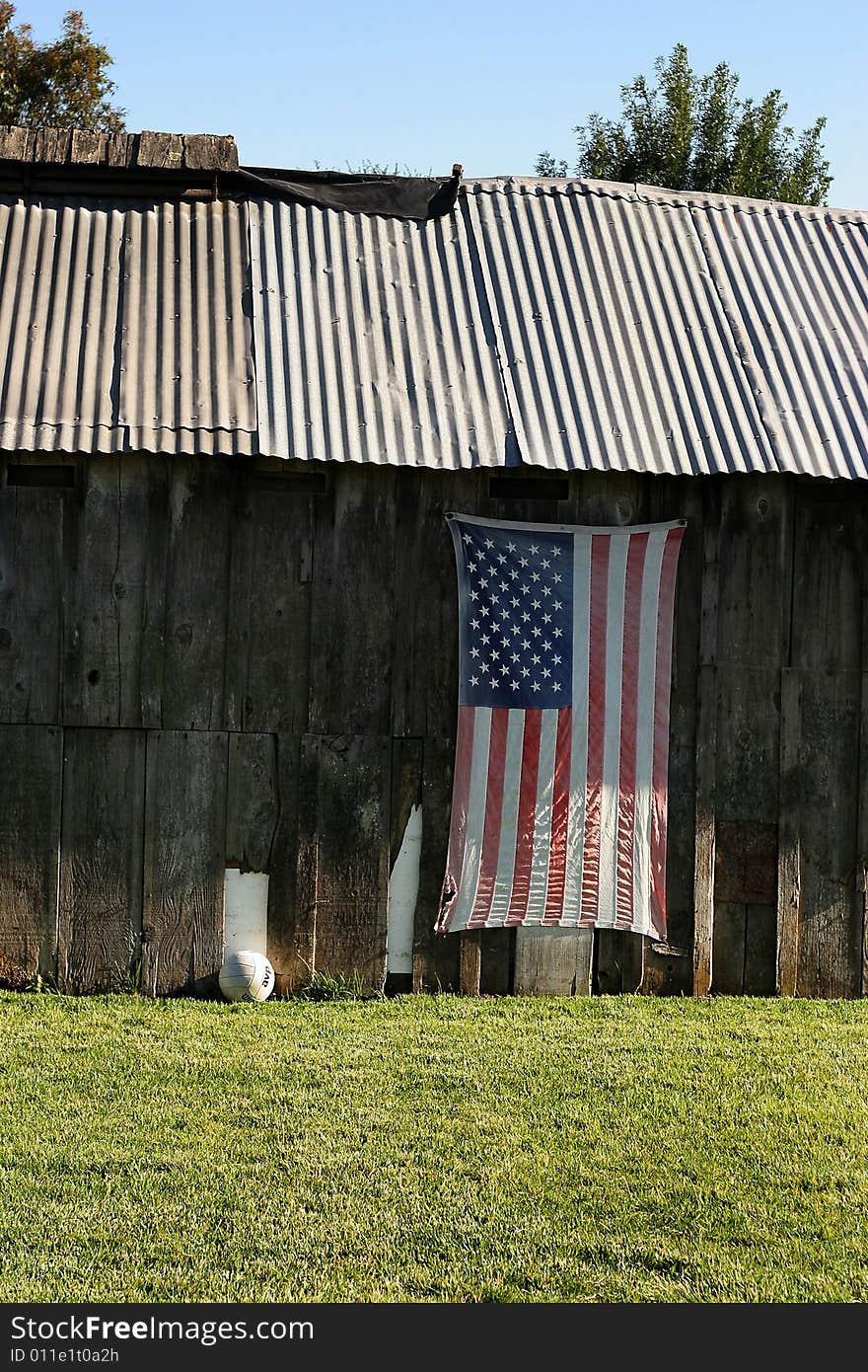 American flag hung on side of an old barn