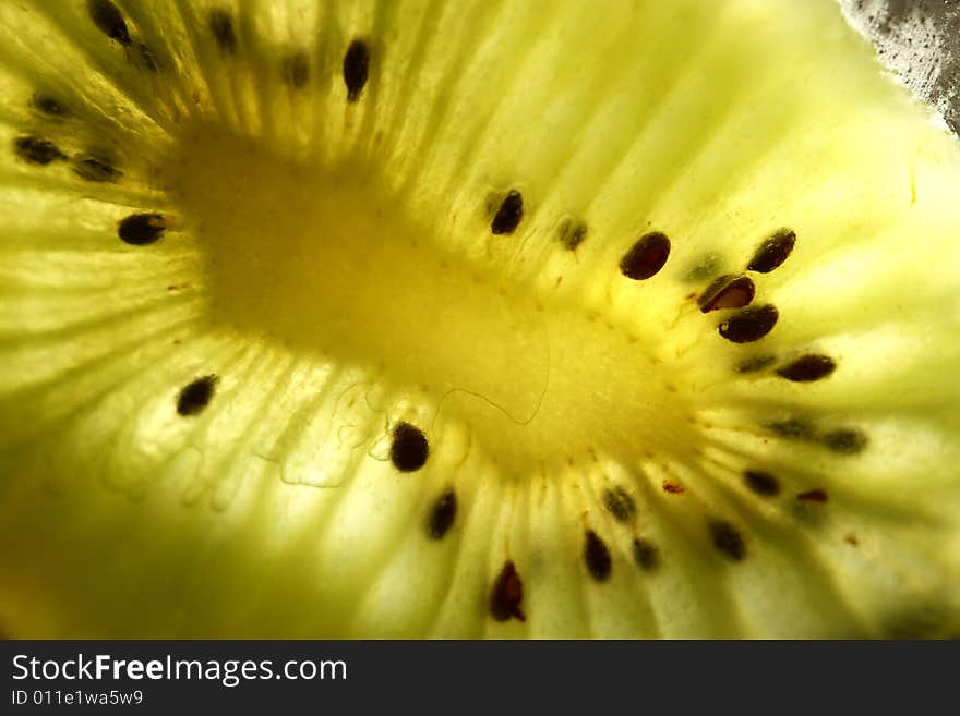 Close up of a kiwi sliced up with light through