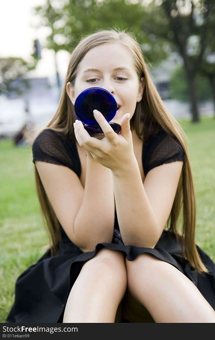 Girl doing makeup in park