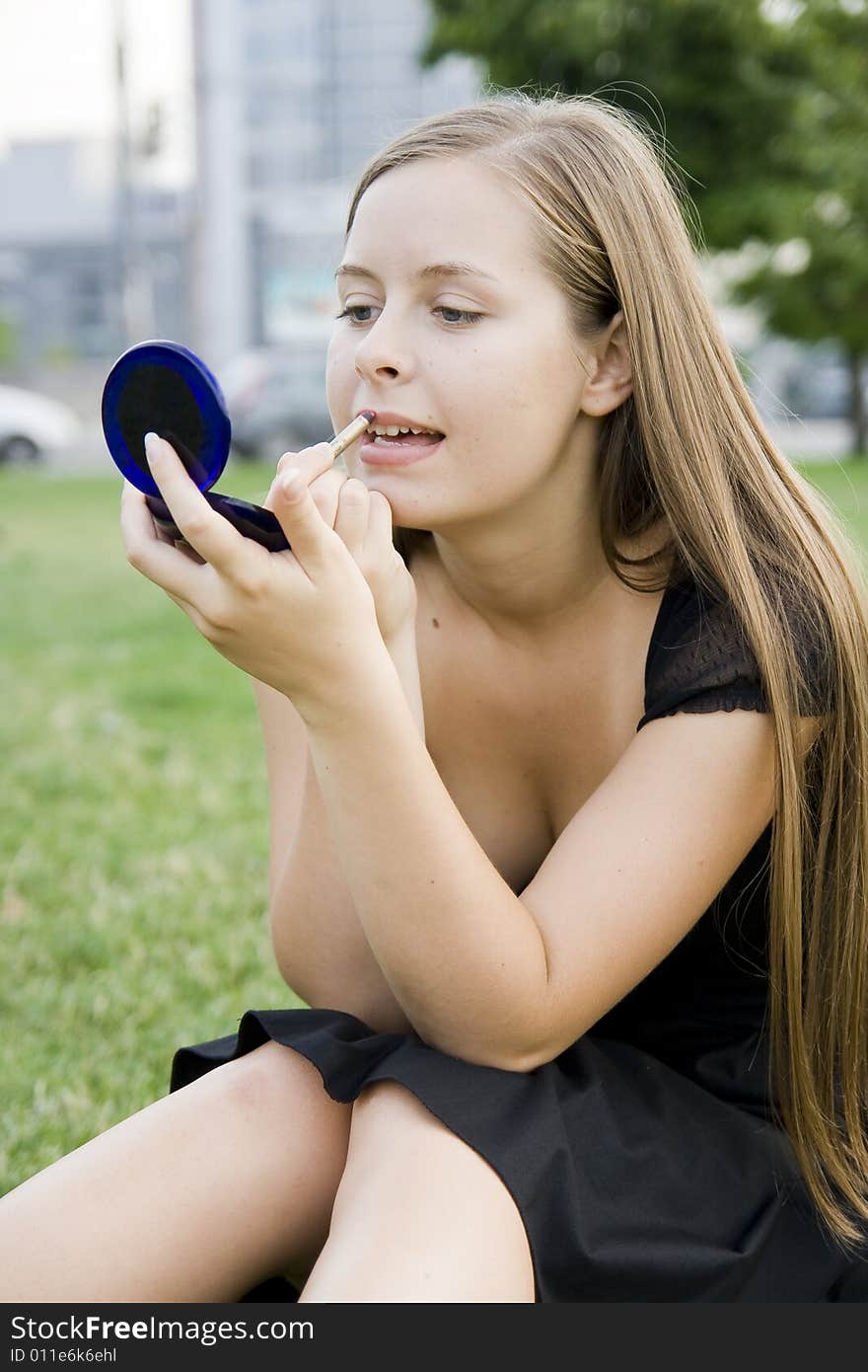 Girl doing makeup in park