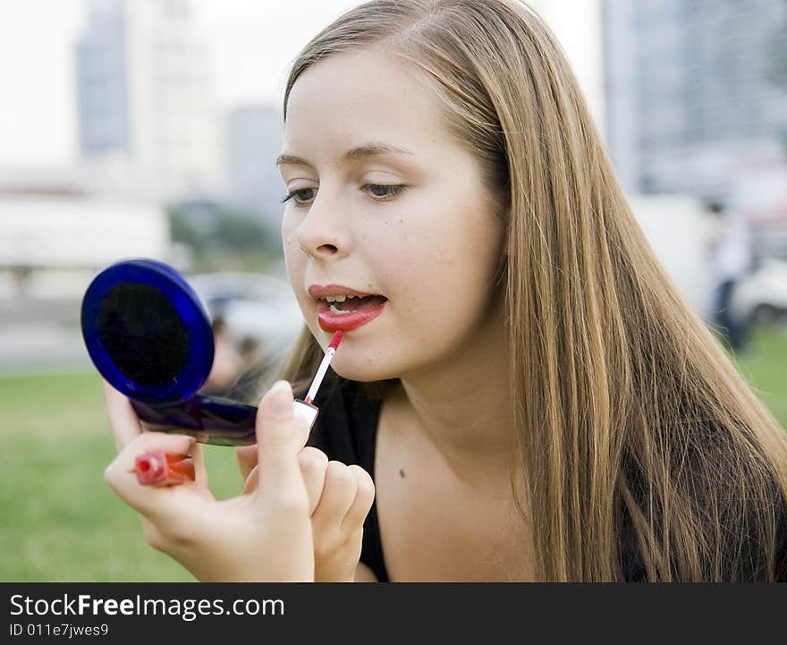 Girl doing makeup in city