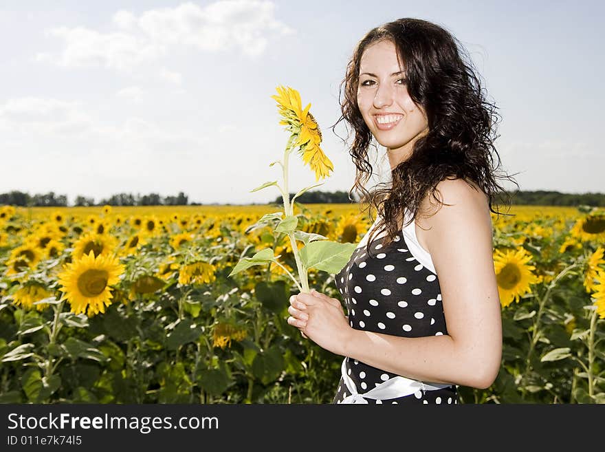 Smiling girl with sunflower on meadow