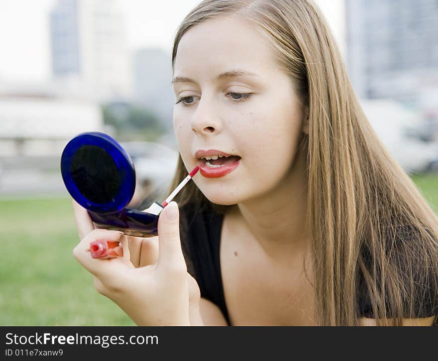 Girl doing makeup in city