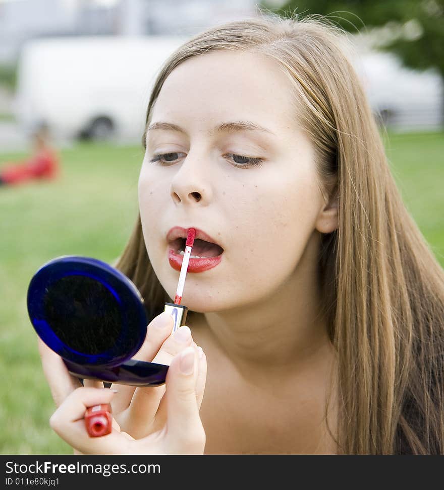 Girl doing makeup in city