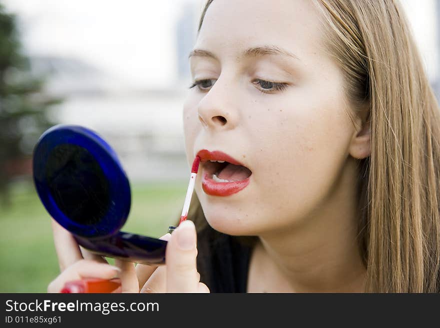 Girl doing makeup in city