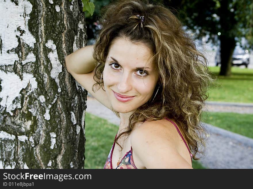 Beautiful smiling girl near birch