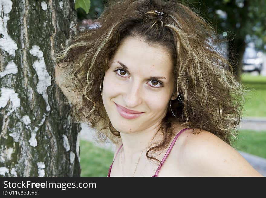 Beautiful smiling girl near birch