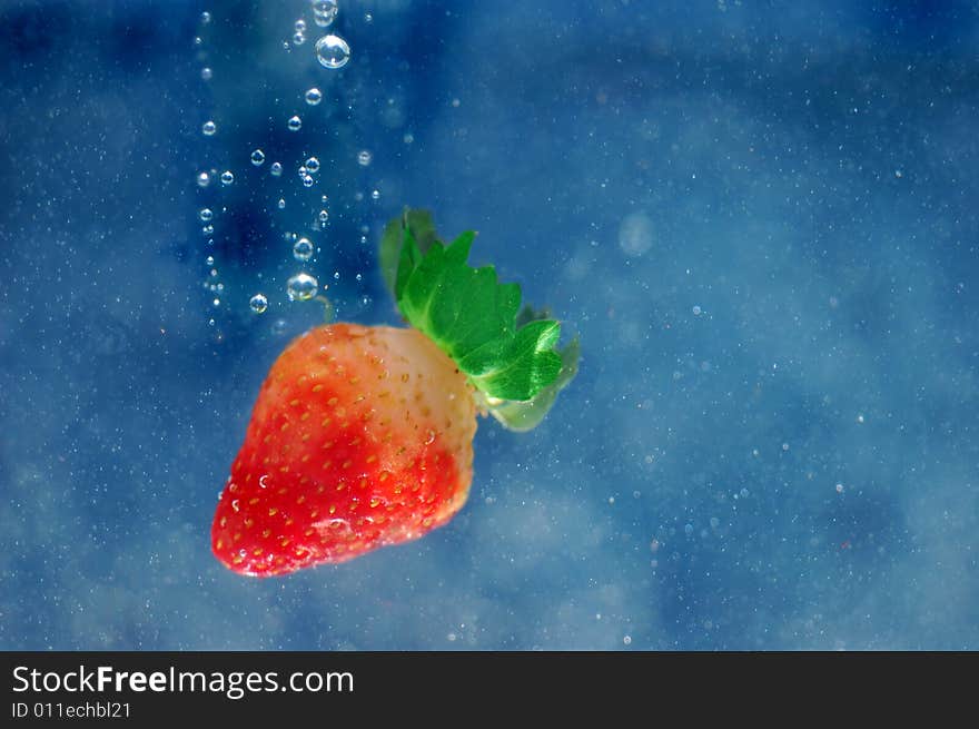 Single strawberrien splashing into water. Single strawberrien splashing into water