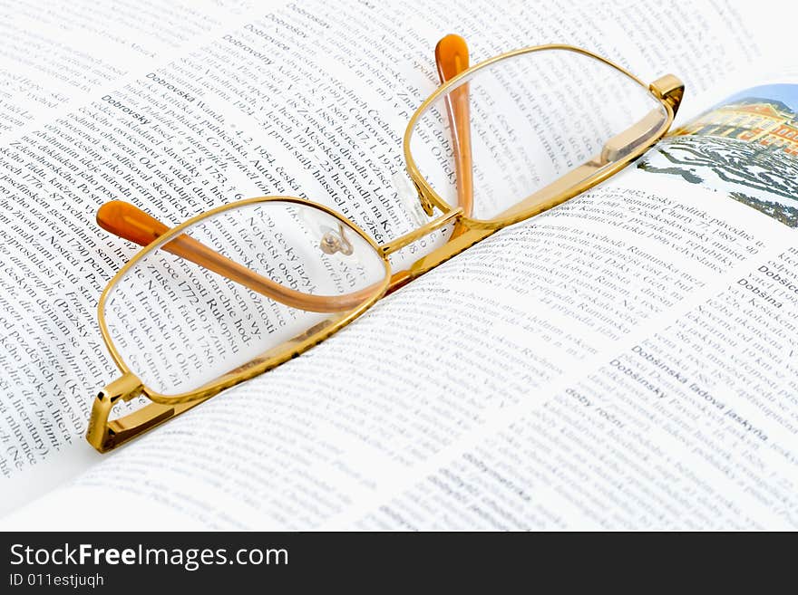 Glasses lying on an open book - close up. Glasses lying on an open book - close up