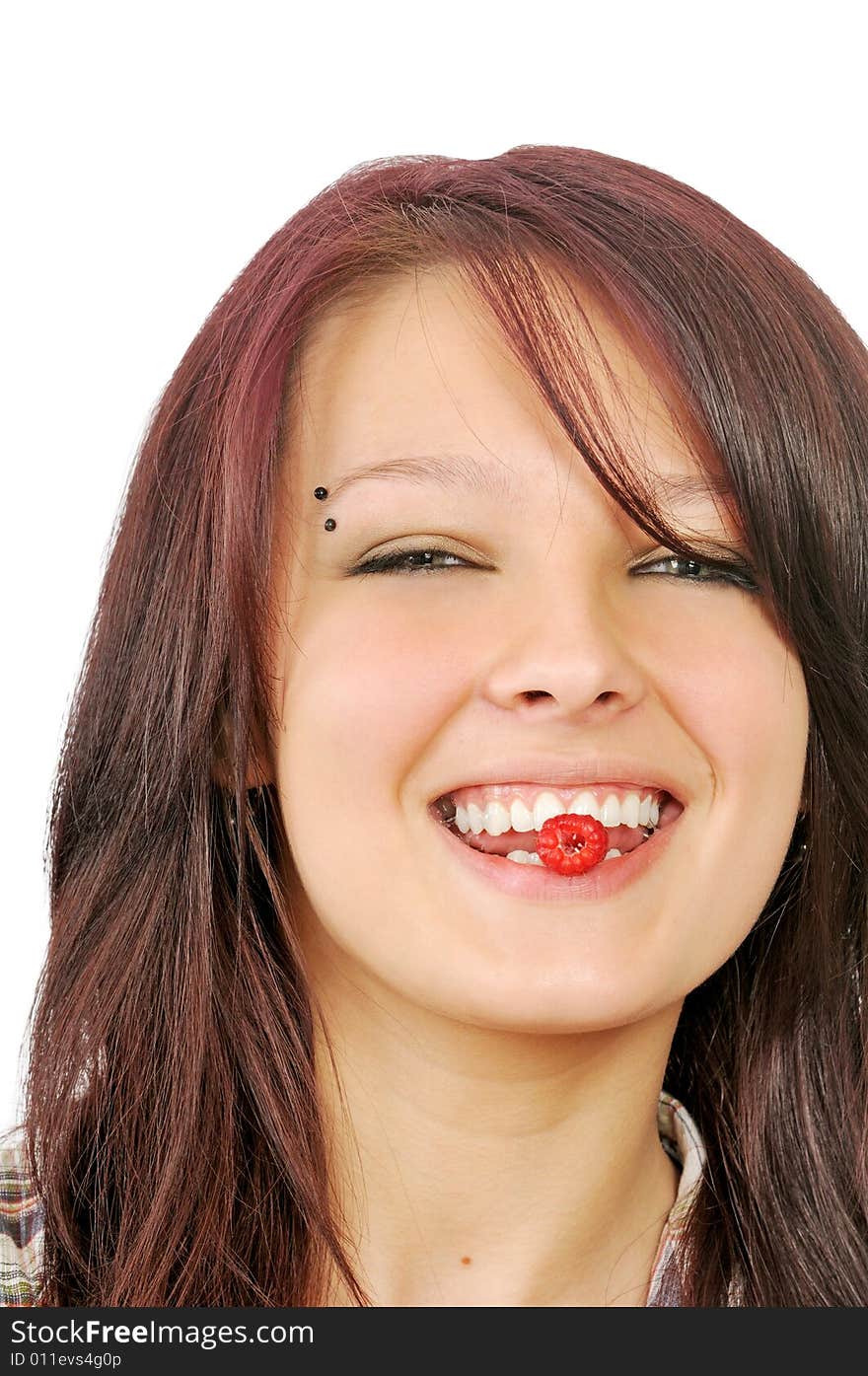 Smiling girl shows raspberry in mouth, isolated on white