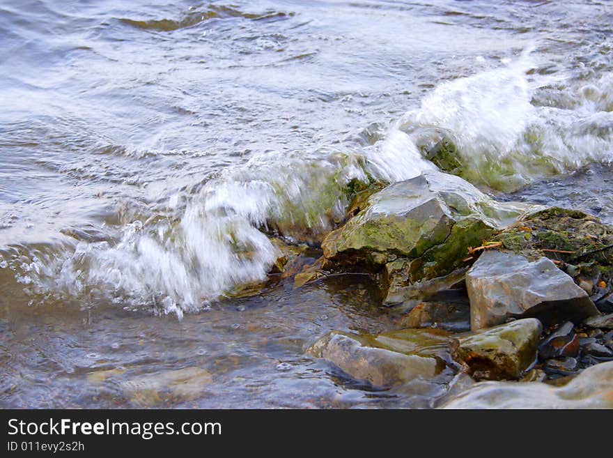 Sea stone covered by white wave