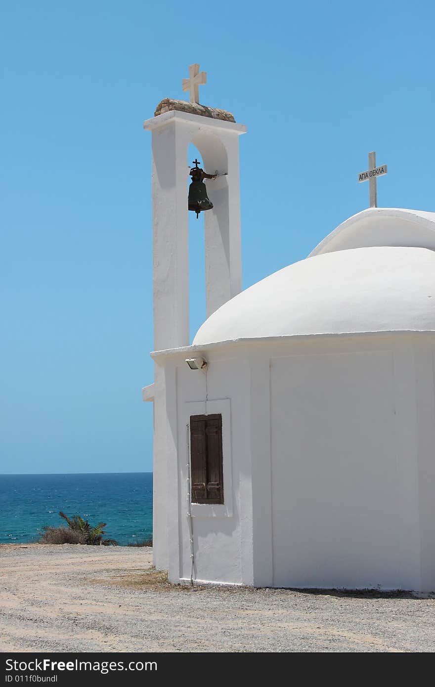 White church with catholic cross over blue sky