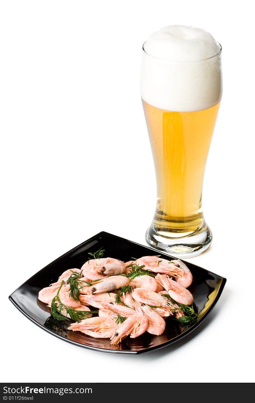 Beer in a glass and a dish with shrimps on a white background