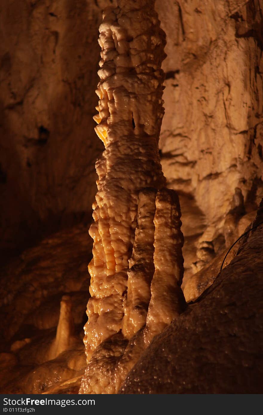 Tall unusual stalagmites and stalactites in the underground cavern in france, vertical