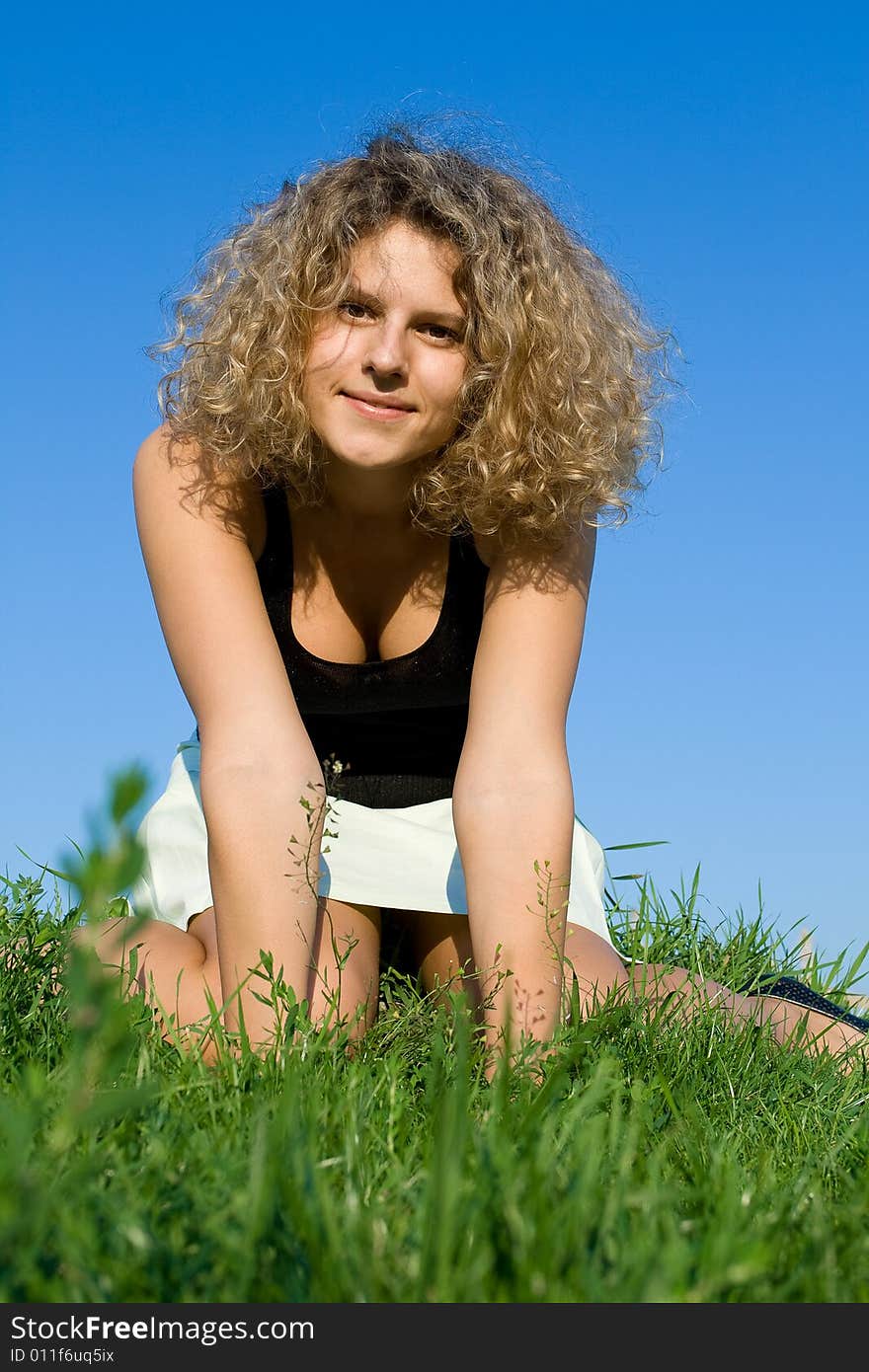 A beautiful lady lies on the grass in the sunny day