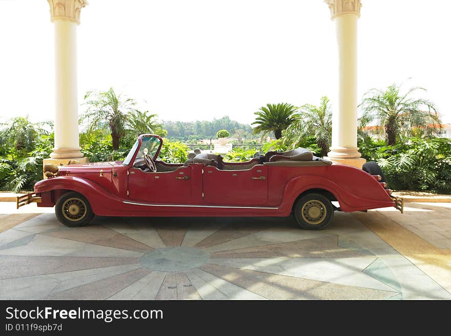 The antiqued car before the hotel hall way.