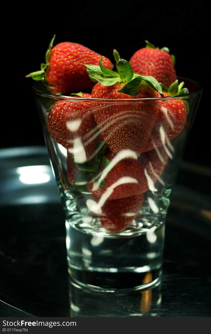 Strawberry in glass on black background